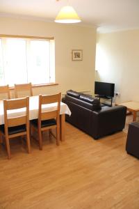 a living room with a black leather couch and a table at Tralee Town Centre Apartments in Tralee