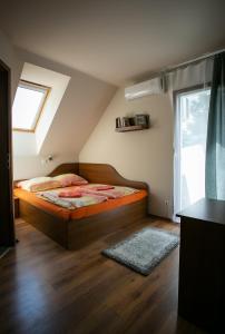 a bedroom with a bed and a window at Forrás vendégház in Dunaegyháza