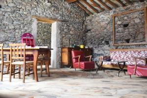 a room with a table and chairs and a stone wall at Dal Ciavatin in Paesana