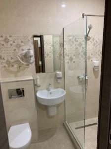 a bathroom with a sink and a toilet and a shower at Hotel Oblaka in Mineralnie Vody