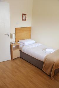a bedroom with a large bed and a nightstand with a bed sidx sidx sidx at Tralee Town Centre Apartments in Tralee +1 photo