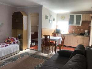 a kitchen and a living room with a table and chairs at Guest House Rózsakert in Egerszalók