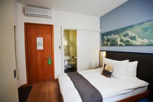 a bedroom with a bed and a wooden door at Hotel Bristol Zurich in Zurich