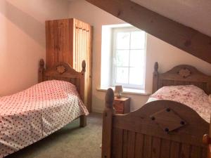 ディナンにあるVal Rive - Le Pintadeau Cottage - Dinanのベッドルーム1室(木製ベッド2台、窓付)