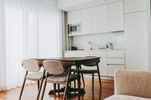 a kitchen with a wooden table and chairs at 54 São Paulo - Exclusive Apartment Hotel in Lisbon