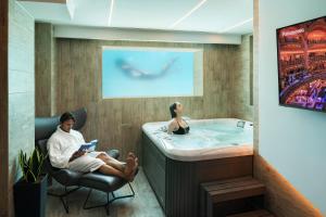 a man and a woman sitting in a bathroom with a tub at Akti Toroni Boutique Hotel in Toroni