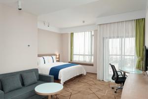 成都市にあるHoliday Inn Express Chengdu West Gate by IHGのベッドとソファのあるホテルの部屋 +37枚の写真