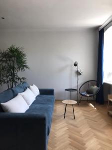 a living room with a blue couch and a table at OnLviv Apartments Rynok Square 18/2 in Lviv