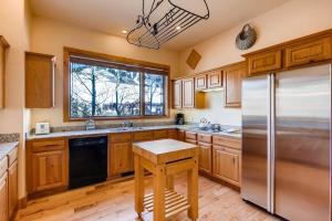 uma cozinha com armários de madeira e um frigorífico de aço inoxidável em 3Br Townhome With Mountain Views & Garage townhouse em Crested Butte