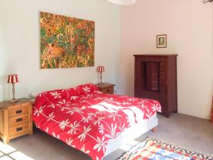 ディナンにあるVal Rive - Monet Apartmentの赤いベッドと壁に絵画が飾られたベッドルーム1室