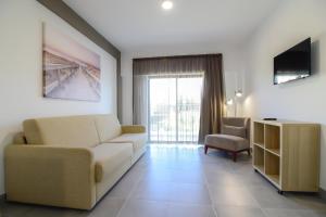 a living room with a couch and a tv at Bayside Salgados in Albufeira