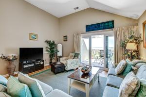 een woonkamer met een bank en een tv bij Pelican Watch 1380 in Seabrook Island