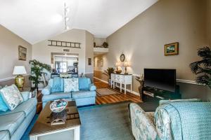 een woonkamer met blauwe banken en een tv bij Pelican Watch 1380 in Seabrook Island