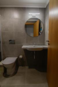 a bathroom with a sink and a toilet and a mirror at Bayside Salgados in Albufeira