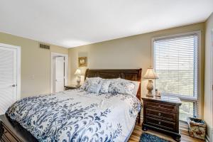 a bedroom with a blue and white bed and a window at Pelican Watch 1380 in Seabrook Island