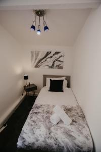 een slaapkamer met een bed met een zwart-witte deken bij LIME St by Prestige Properties SA in Barrow in Furness