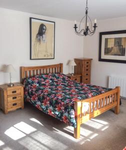 a bedroom with a bed with a floral bedspread at Val Rive - Brandily Apartment in Dinan