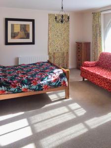 a bedroom with a bed and a couch and a chair at Val Rive - Brandily Apartment in Dinan