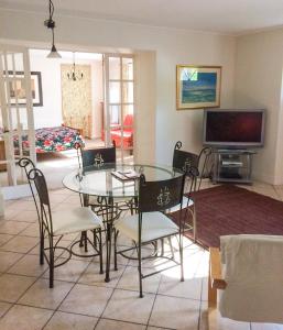 a living room with a glass table and chairs at Val Rive - Brandily Apartment in Dinan