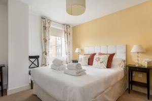 a bedroom with a large white bed with towels on it at Vista in Poole