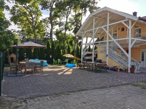 a patio of a house with tables and umbrellas at Silver Beach Resort in Zamárdi