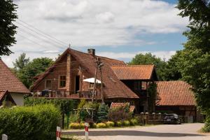 a house with brown roofing on a street at Nowe Kawkowo 28 in Jonkowo