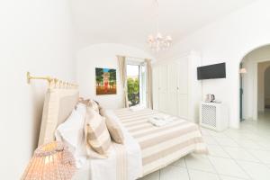una camera bianca con un letto e una finestra di Queen Suite - Luxury Rooms a Ischia
