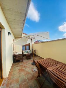 eine Terrasse mit einem Tisch und einem Sonnenschirm in der Unterkunft La Casona del Gallo in Ábalos