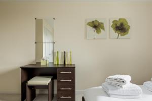 een slaapkamer met een bureau, een stoel en een spiegel bij Bay Retreat in Poole
