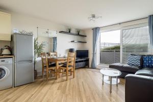 een keuken en een woonkamer met een tafel en een bank bij Bay Retreat in Poole