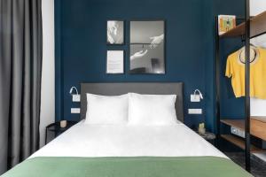 - une chambre dotée d'un lit avec un mur bleu dans l'établissement Play Theatrou Athens, à Athènes