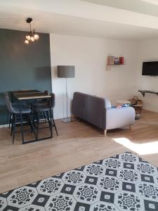 a living room with a couch and a table at Appartement Pierres de Loire- Linge inclus -1er étage in La Bohalle