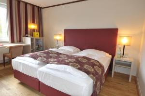ein Schlafzimmer mit einem großen Bett in einem Hotelzimmer in der Unterkunft Ambassador Parkhotel in München