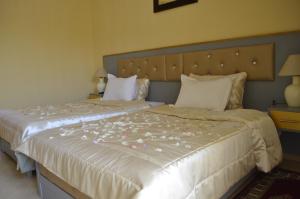 um quarto com duas camas com flores em Almounia Hotel & Spa em Taroudant