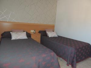 2 Betten in einem kleinen Zimmer mit in der Unterkunft APARTAMENTO NURIA GONZÁLEZ GRANDA in Peñíscola
