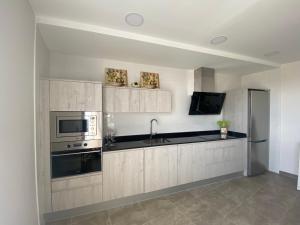a kitchen with white cabinets and a stainless steel refrigerator at La Casona del Gallo in Ábalos