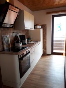 a kitchen with white cabinets and a stove top oven at Haus Rosi in Weiskirchen
