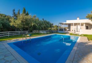 a swimming pool in front of a house at Ammoudi Harmony Villa in Amoudi