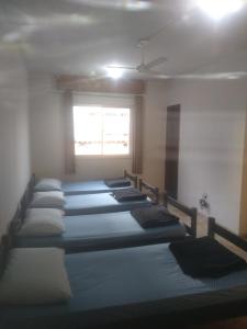 a row of beds in a room with a window at Sollarium GINI Suítes in Guarapari