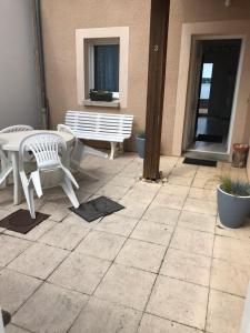 a patio with two white chairs and a bench at Maison bord de Lac de Pareloup in Salles-Curan +14 photos