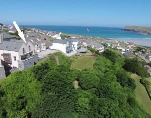 an aerial view of a town with houses and the ocean at Stepper Point in Polzeath