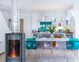 a kitchen with a dining table and blue chairs at Stepper Point in Polzeath