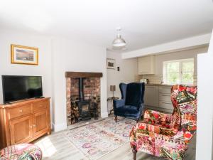 a living room with two chairs and a television at 3 Higher Lane in Macclesfield