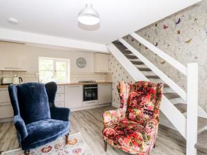 a living room with two chairs and a staircase at 3 Higher Lane in Macclesfield