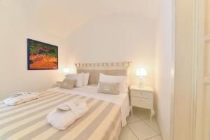 a white bedroom with two towels on a bed at Queen Suite - Luxury Rooms in Ischia