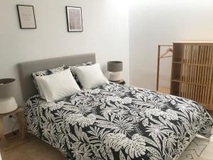 1 dormitorio con 1 cama con manta blanca y negra en Apartamento Espaçoso Sesimbra en Sesimbra