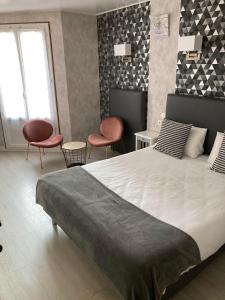 a bedroom with a large bed and two chairs at Hotel du Nord - Ville-Haute in Saint-Flour