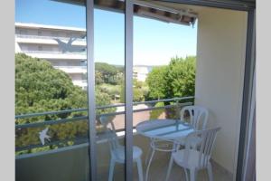 a balcony with a table and chairs and a window at F2 Climatisé Piscine Proche Plage in Cavalaire-sur-Mer