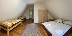 um quarto no sótão com 2 camas e um quarto com uma escada em Tavas Vendégház em Karancsalja