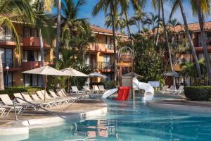 a pool at a resort with chairs and a slide at Holiday Inn Resort Ixtapa All-Inclusive, an IHG Hotel in Ixtapa